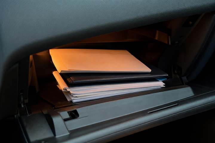 Documentos organizados no porta-luvas do carro